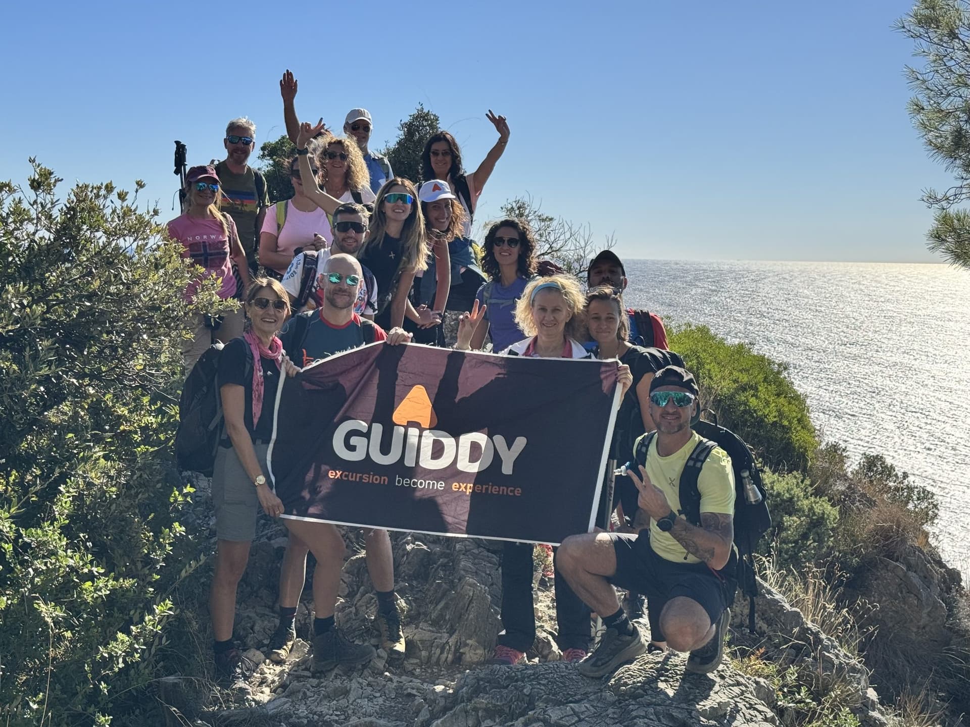 Un gruppo Guiddy con la bandiera, il mare alle spalle