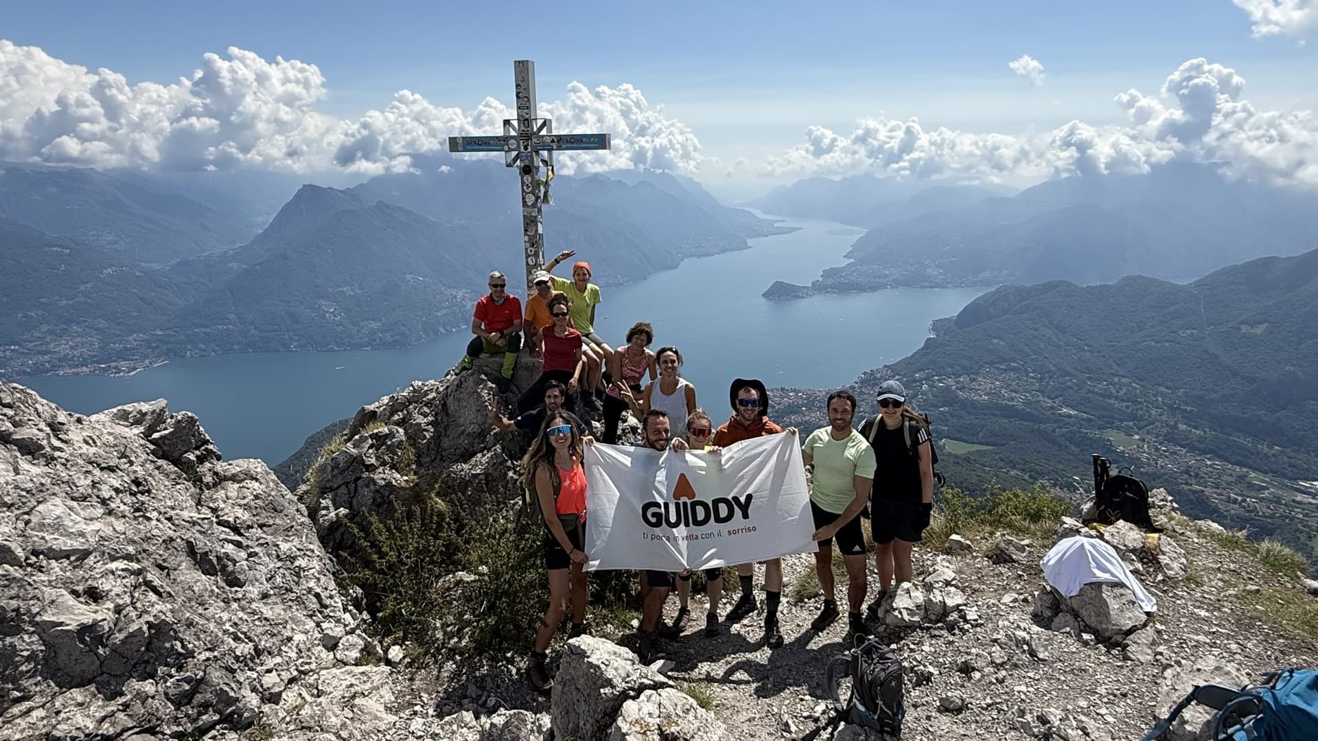 Un gruppo Guiddy alla croce di vetta sopra il lago
