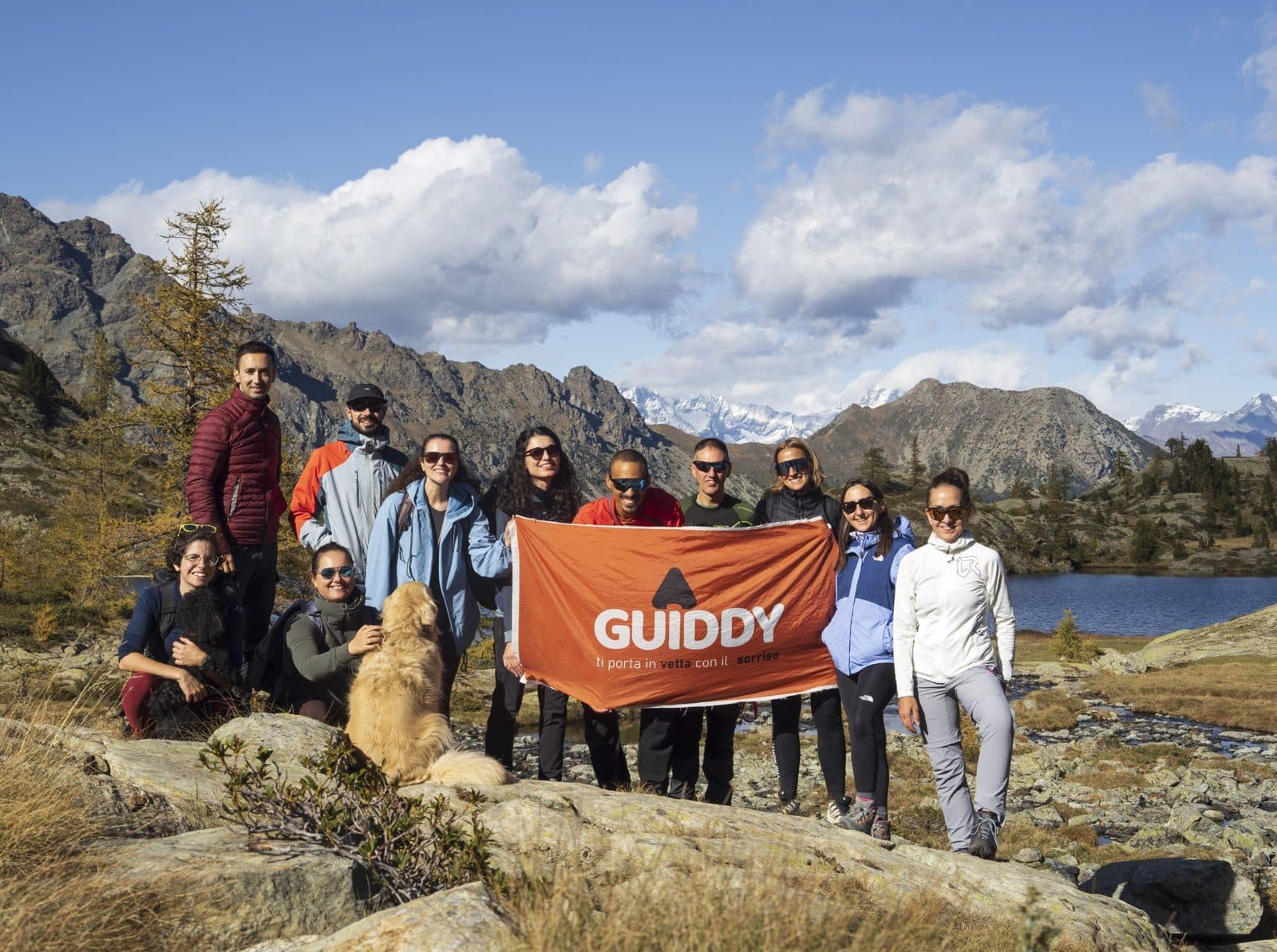 A Guiddy group with the orange flag next to an alpine lake