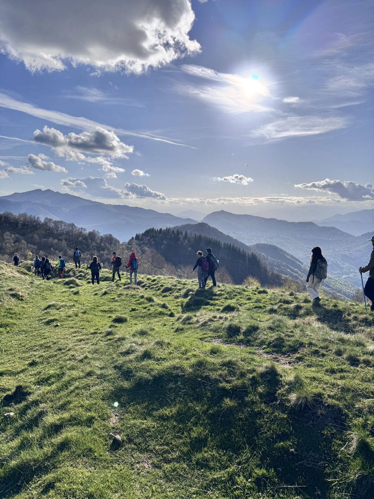 Il gruppo in fila sulla cresta erbosa, al tramonto