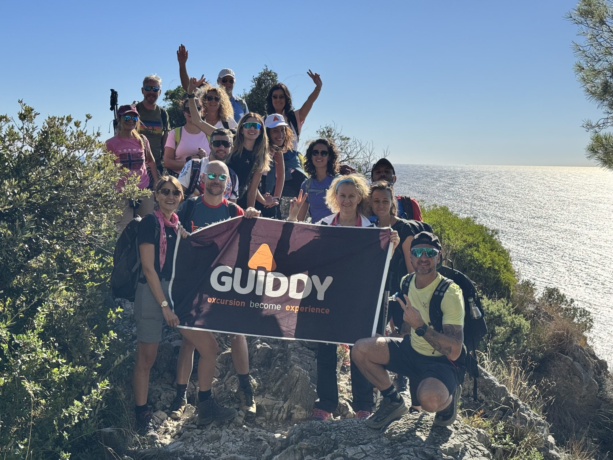 Un gruppo Guiddy con la bandiera, sul sentiero a picco sul mare