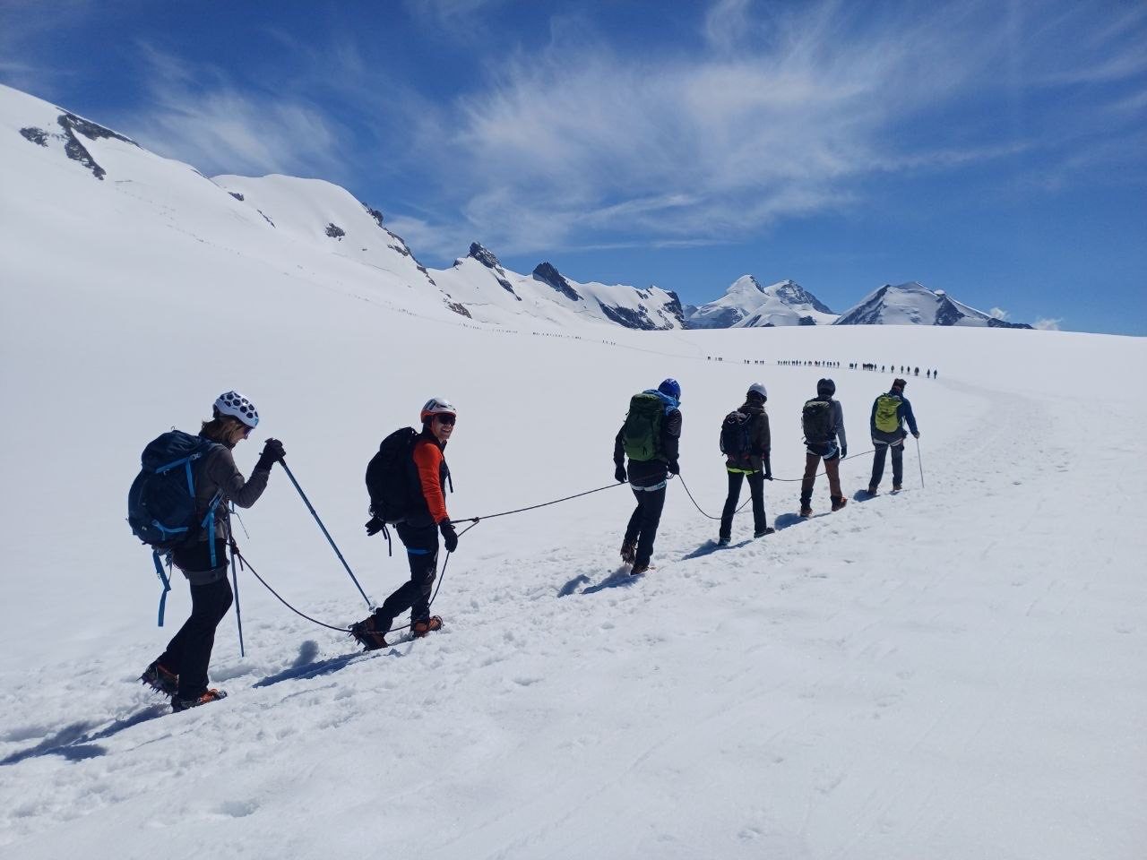 Tre scialpinisti in salita su neve fresca